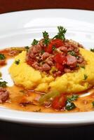 Corn polenta with sausage and tomatoes photo