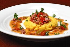 Corn polenta with sausage and tomatoes photo