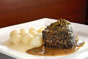 Filet au Poivre with potatoes and sauce photo