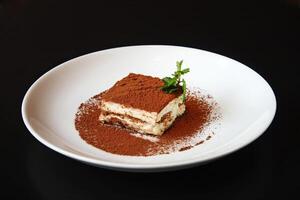 Tiramisu, classic Italian dessert covered in chocolate on top photo