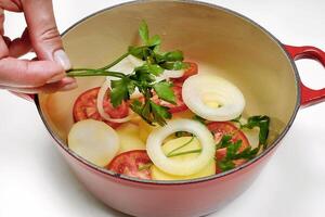 preparing fish moqueca in the red pan photo