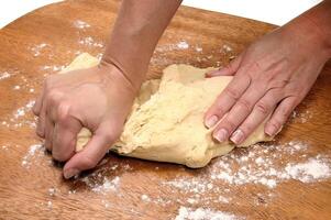 rolling out dough on wooden table to make bread photo