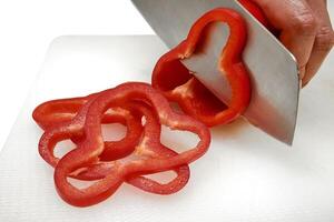cutting bell pepper into slices for cooking photo