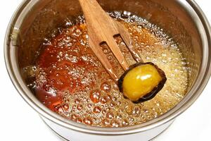 Brazilian sweet, mother-in-law's eye, being caramelized in the pan photo