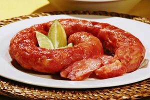 Calabrian sausage baked with lemon on plate photo