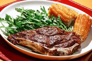 filete en el hueso con vegetales y asado maíz foto