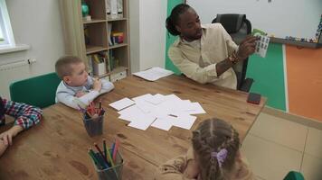 ein afrikanisch amerikanisch Lehrer unterrichtet ein Gruppe von Kinder mathematik.schule zum Kinder, Lehren Jugendliche, dazugewinnen Wissen, lernen das Sprache. video