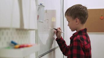 garçon élève dessine sur le tableau noir tandis que en train d'étudier à école.école pour enfants, enseignement adolescents, Gain connaissance, apprendre le langue. video