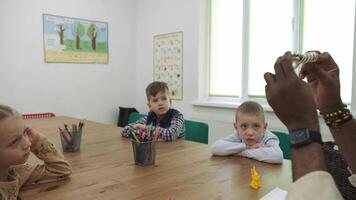 un africano americano profesor y un grupo de niños son estudiando frutas y animales en el aula.escuela para niños, enseñando adolescentes, ganancia conocimiento, aprender el idioma. video