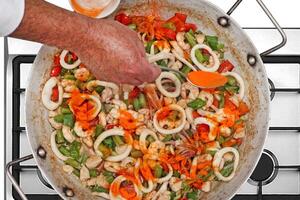 step-by-step guide to making Paella Valenciana, a classic Spanish dish with seafood and saffron rice photo