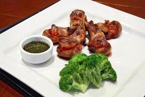 Rack of lamb, classic cut of delicious chops with broccoli and sauce photo