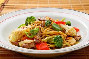 Classic yakisoba with meat, pasta and chopped vegetables photo