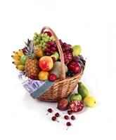 basket with grapes, orange, pineapple, mango, bananas and other fruits on white background photo