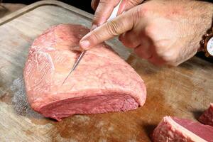 professional butcher teaching step by step how to prepare picanha, a Brazilian cut of meat photo