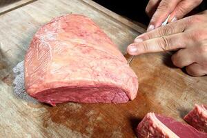 professional butcher teaching step by step how to prepare picanha, a Brazilian cut of meat photo