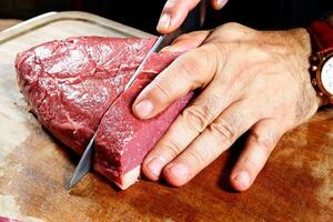 professional butcher teaching step by step how to prepare picanha, a Brazilian cut of meat photo