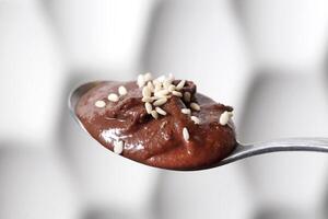 chocolate cream with sesame on spoon photo