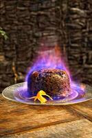 Christmas pudding being flambeed in its final step to be served photo