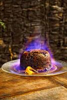 Christmas pudding being flambeed in its final step to be served photo