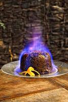 Christmas pudding being flambeed in its final step to be served photo