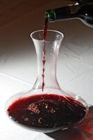 rojo vino siendo servido en un licorera durante saboreo foto
