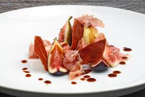 fresh figs with parma ham on plate photo