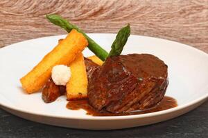 fillet in Madeira sauce with asparagus on plate photo