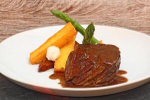 fillet in Madeira sauce with asparagus on plate photo