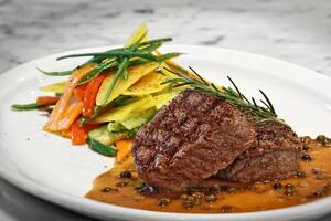 fillet au poivre vert with vegetable slices on plate photo