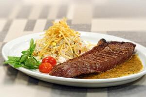 filete en salsa con arroz y papas fritas foto