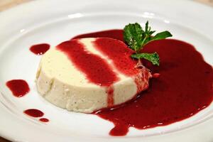 vanilla panna cotta with red fruit syrup photo