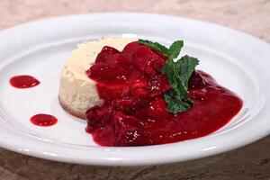 tarta de queso con rojo Fruta jarabe en plato foto