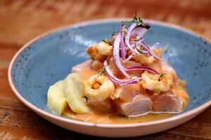 Ceviche, classic Peruvian dish with raw fish, onions, pepper and lemon juice photo