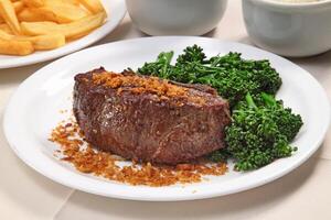 tall fillet with broccoli and chopped and fried garlic photo
