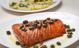 Grilled salmon with capers, potatoes and passion fruit sauce photo