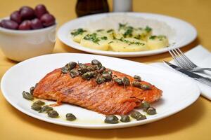 Grilled salmon with capers, potatoes and passion fruit sauce photo