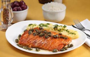 Grilled salmon with capers, potatoes and passion fruit sauce photo
