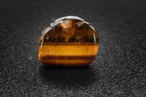 tigers eye, brazilian gemstone on dark background photo