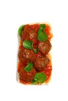 meatball sandwich in tomato sauce with lettuce on ciabatta bread seen from above photo