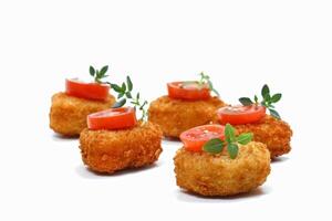 chicken nuggets with cherry tomato slice on white background photo