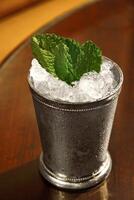 Mint Julep, classic drink with mint, bourbon whiskey, sugar syrup and aromatic bitters photo
