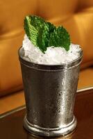 Mint Julep, classic drink with mint, bourbon whiskey, sugar syrup and aromatic bitters photo