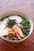 Soba, classic Japanese cuisine, with soba or udon noodles, egg, ginger, pork loin and green onions photo