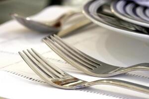 sophisticated tables with plates, cutlery and fine glasses close-up photo