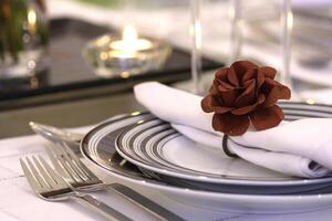 sophisticated tables with plates, cutlery and fine glasses close-up photo