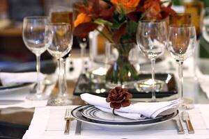 sophisticated tables with plates, cutlery and fine glasses close-up photo