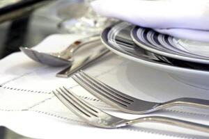 sophisticated tables with plates, cutlery and fine glasses close-up photo