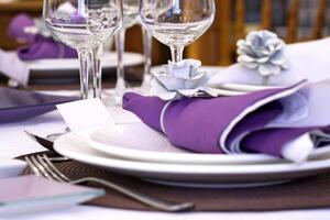 sophisticated tables with plates, cutlery and fine glasses close-up photo