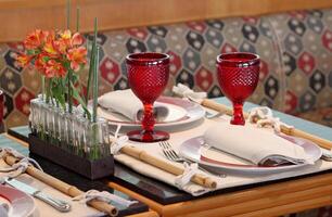 sophisticated table arrangements with red jackfruit glasses photo