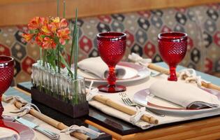 sophisticated table arrangements with red jackfruit glasses photo